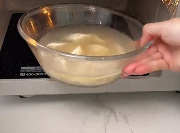 女生在公司内用微波炉加热速冻饺子 5分钟搞定不洗锅