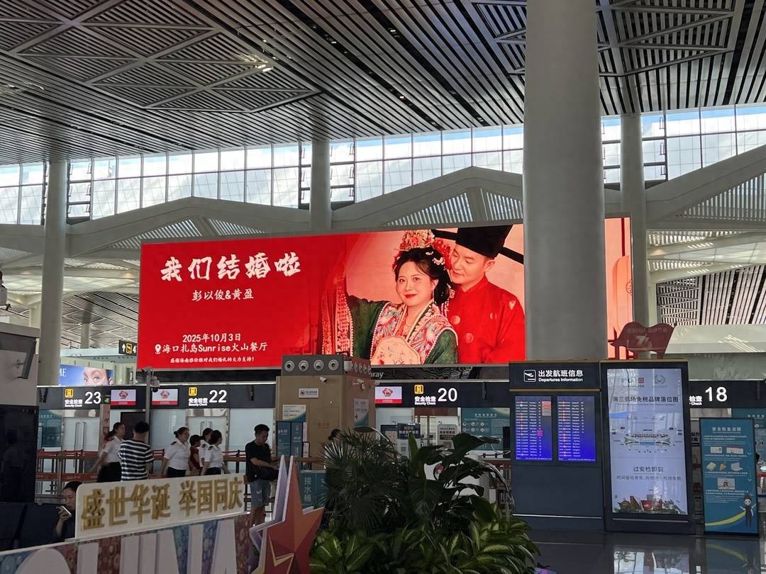 新人结婚请柬在机场88块屏幕连播8天，预留2桌空席引热议，网友：高调得好！
