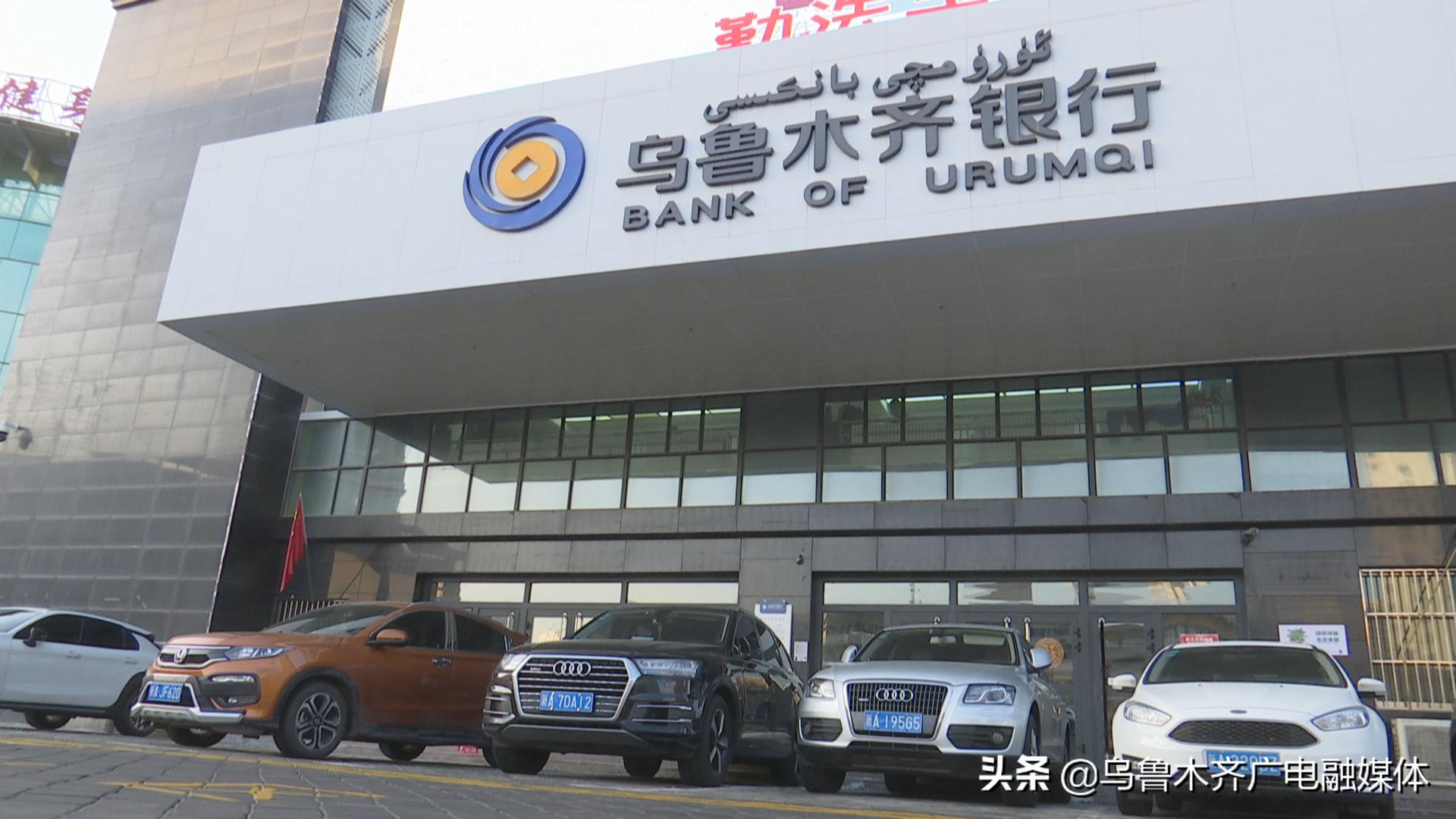 乌鲁木齐银行总行大楼外观，建筑外立面以灰色石材和白色墙面为主，门楣处悬挂维吾尔文、中文及英文字样的银行标识