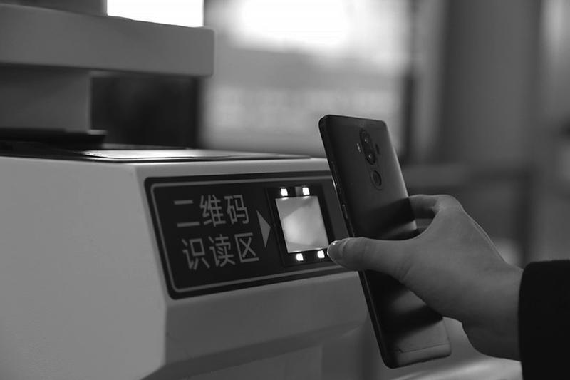 旅客使用手机扫描电子临时乘车身份证明二维码通过闸机