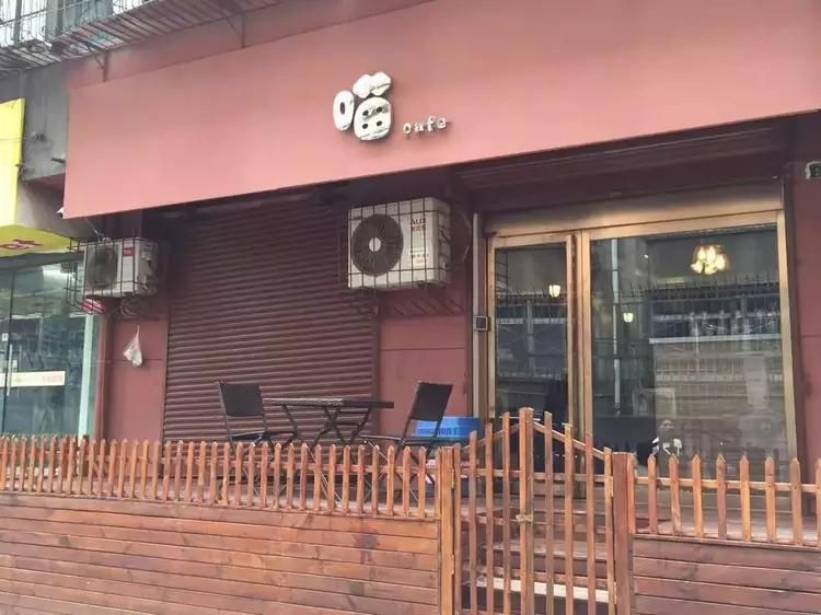 西安牛咖店铺外观,暗红色招牌和木质小平台营造温馨氛围